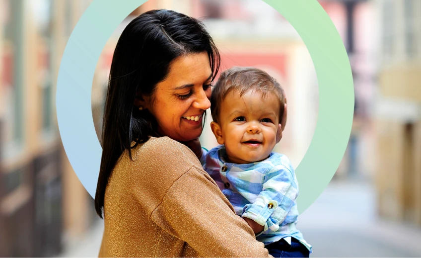 toddler living with achondroplasia held by their mother